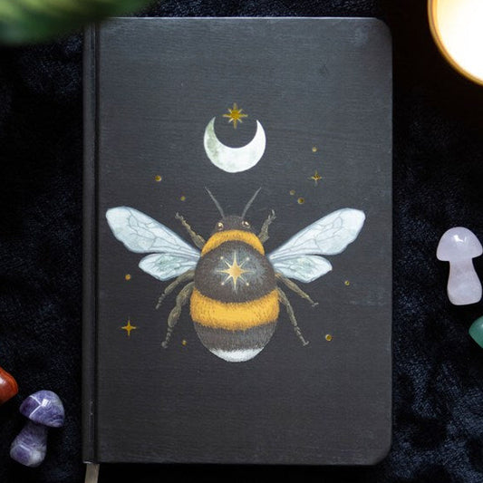 Black A5 lined notebook with a forest bee design, enhanced by celestial details and a ribbon marker.