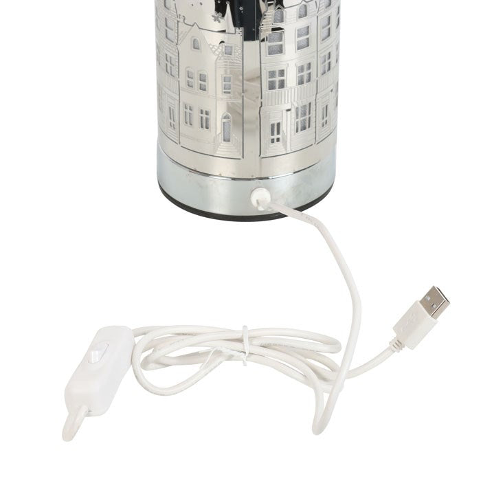 Christmas seasonal electric wax melter and oil burner with Christmas village motif. Close up of USB plug and on switch.