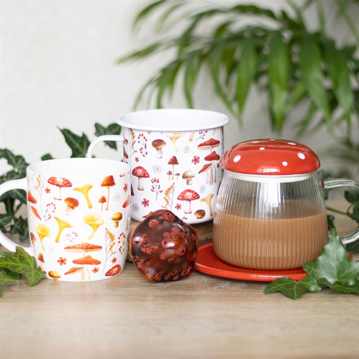 Enamel mug with all-over mushroom print. Presented alongside other items from the same range.