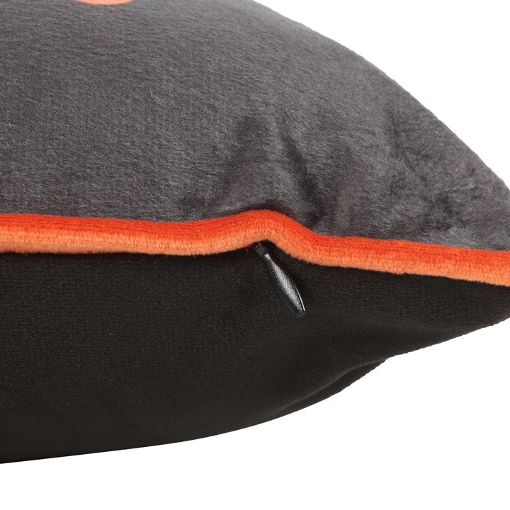 Rectangular Halloween throw cushion. Black background with an orange trim, Welcome to our Haunted House text and jack o' lantern motif. Close up of zip closure.