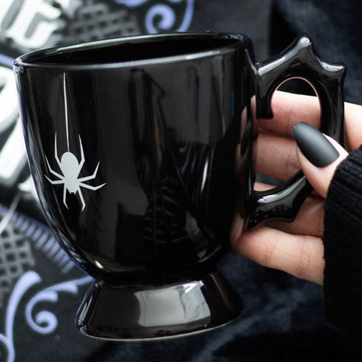 Black gothic-style ceramic mug with thorny-design handle and charming spider detailing.