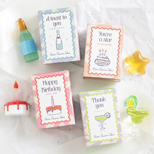 Glass pocket tokens in classic party-icon design. Champagne bottle, cocktail glass, star and birthday cake. 