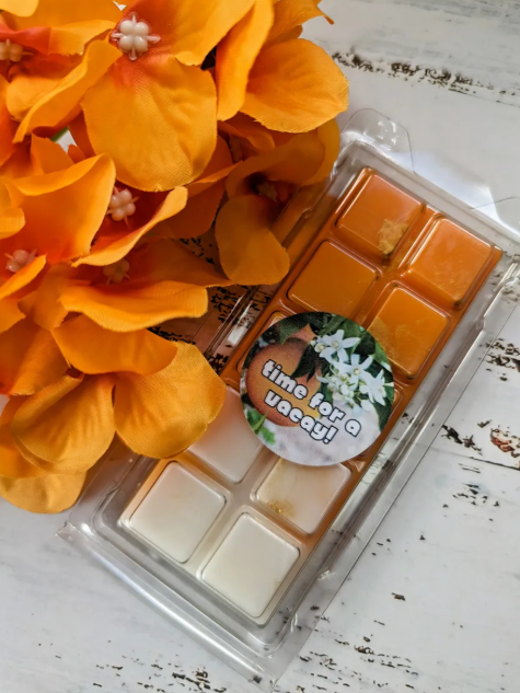 Time for a Vacay coconut wax melt. Orange and cream snap bar with golden shimmer accents. 