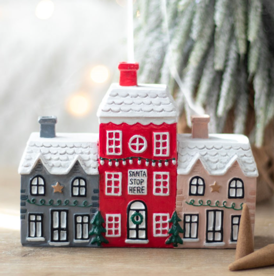 Ceramic incense cone burner shaped like a charming Christmas village with smoking chimney effect.