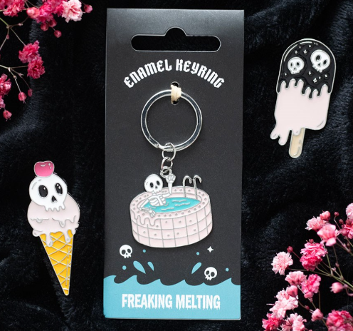 Dead Cool enamel keyring shaped like a skeleton chilling in a pink swimming pool. 