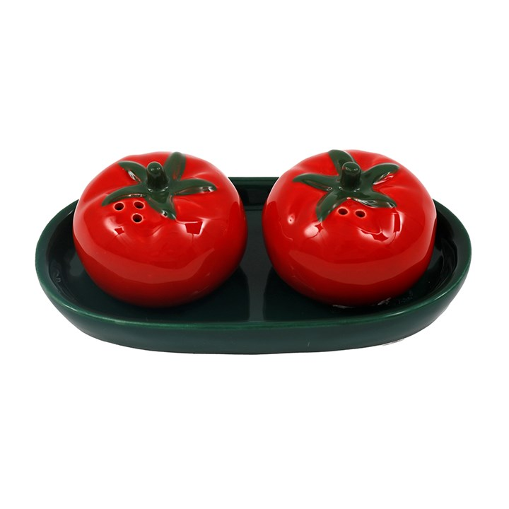 Pair of tomato shaped salt and pepper shakers, presented in a green tray. 
