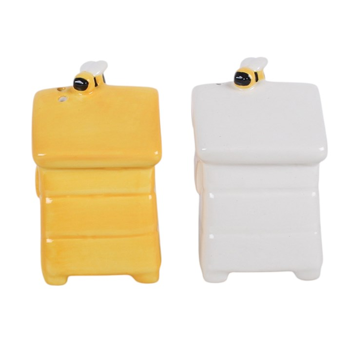 A set of white and yellow ceramic salt and pepper shakers, shaped like traditional beehives with a bee sitting on top. 