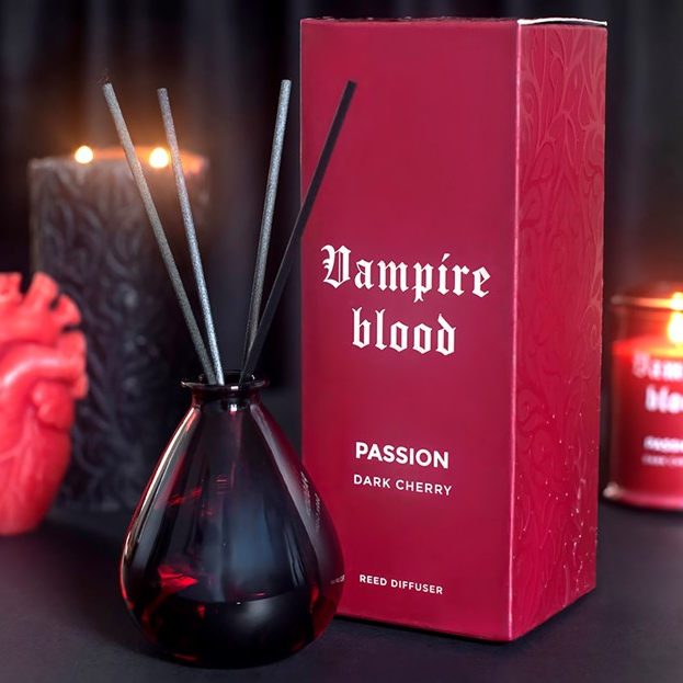 Vampire Blood reed diffuser. A deep red teardrop glass bottle with dark reeds.