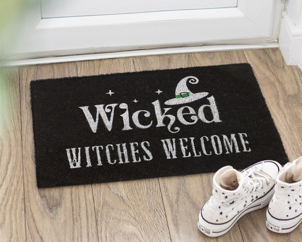 Black decorative doormat with 'Wicked Witches Welcome' text and a witch's hat graphic on black background.