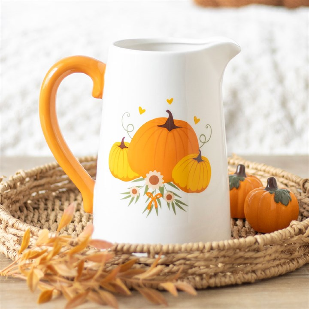White pitcher flower jug with trio of pumpkin motif and orange handle. 