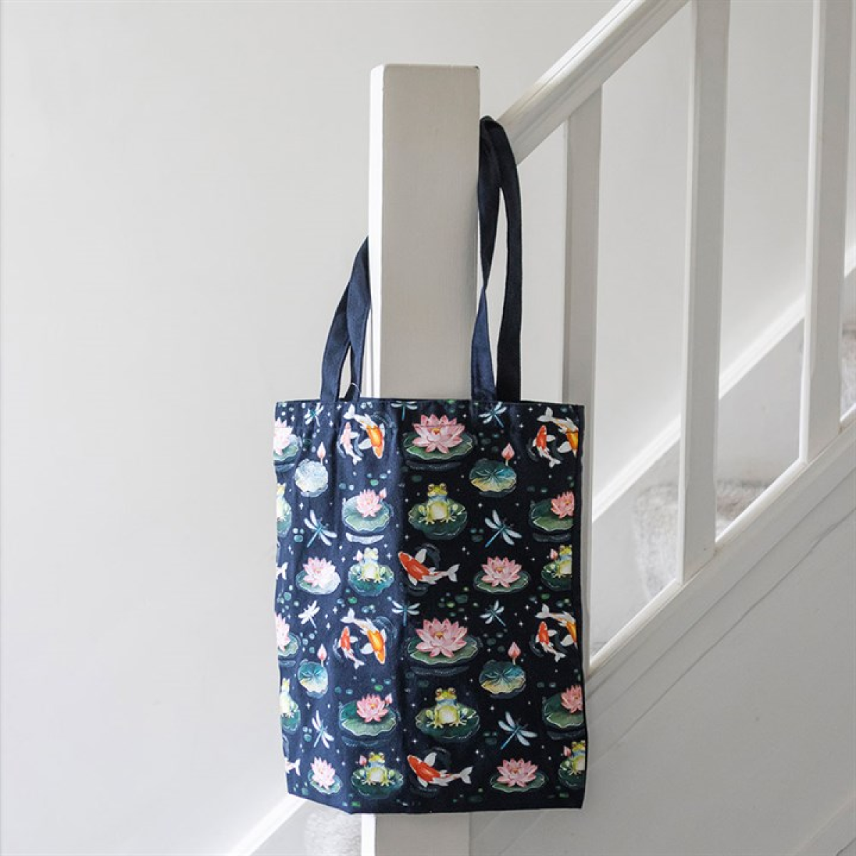 Navy canvas tote bag with koi and lily-pad motif. 