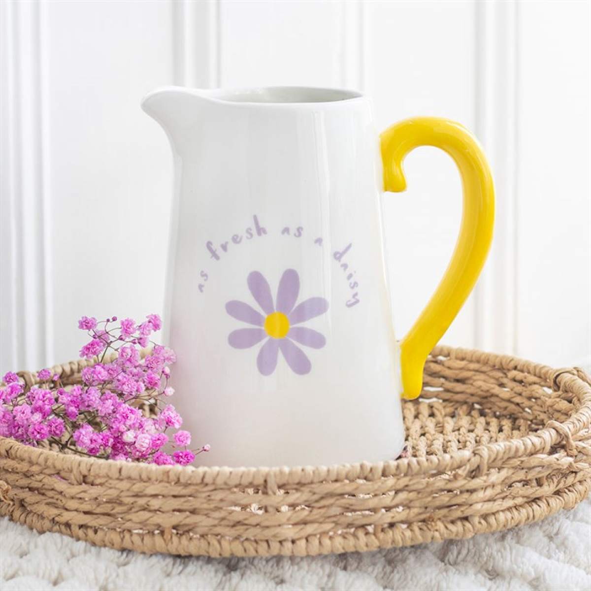 White ceramic flower jug with purple floral design, fresh as a daisy text and yellow handle. 