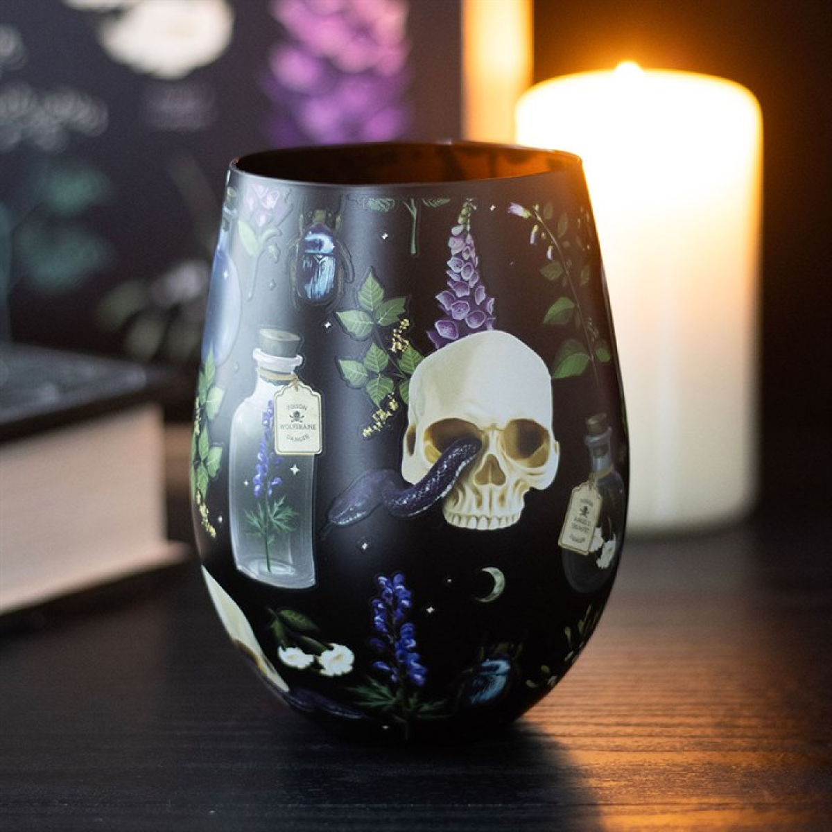 Black stemless wine glass covered in a poisonous plants, potion bottle and skull motif.