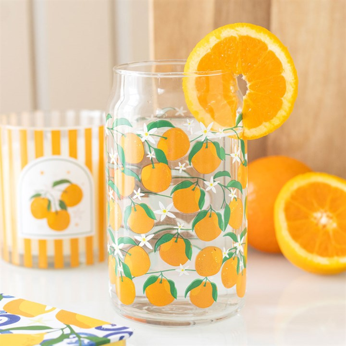 Can-style water glass decorated with orange fruit motif. 