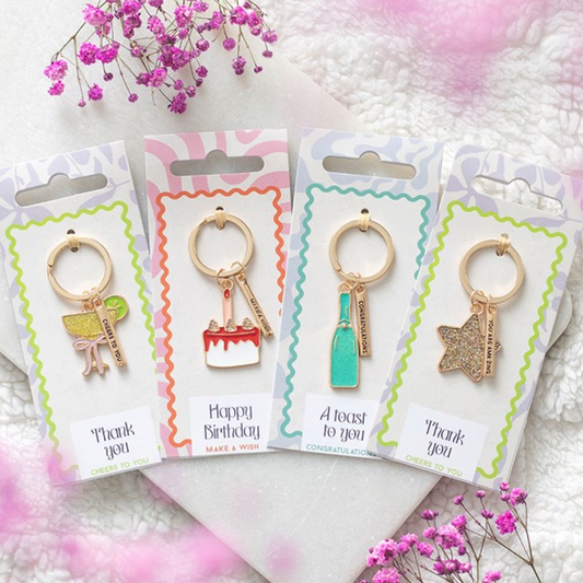 Set of 24 enamel party-icon keyrings. Champagne bottle, cocktail glass, star and birthday cake. 