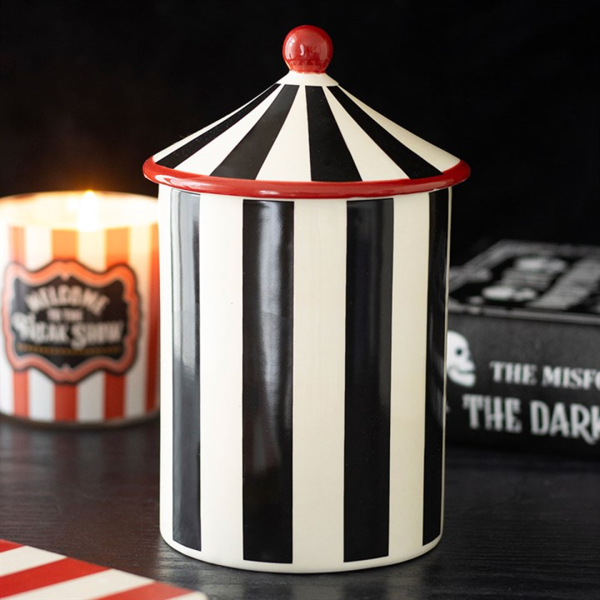 Black and white striped circus tent shaped storage jar.