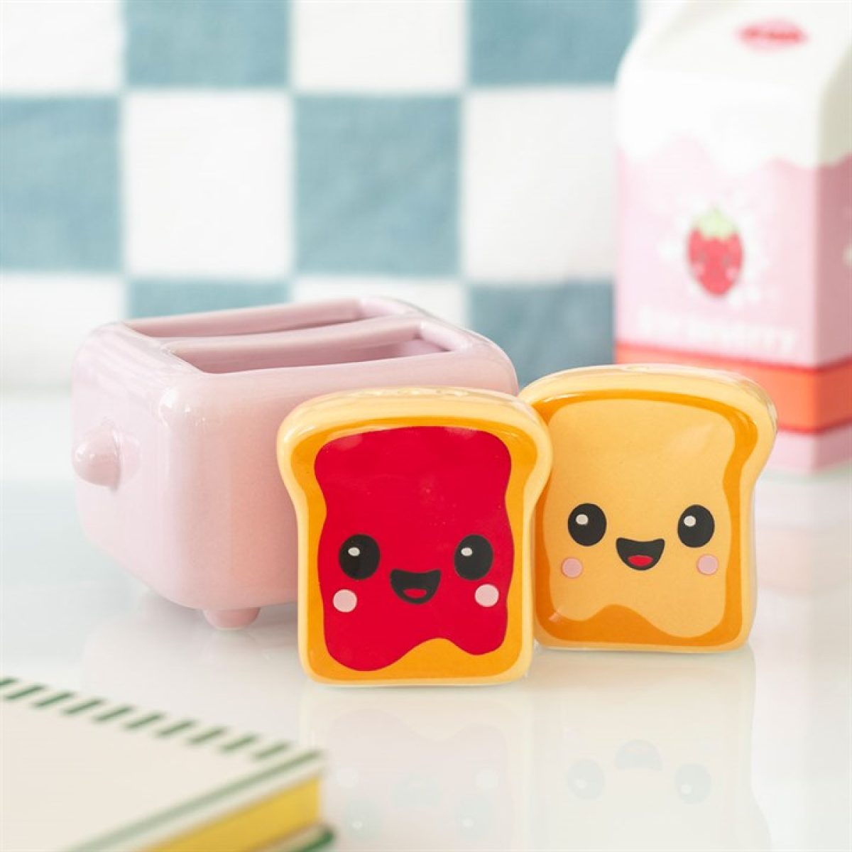 Two kawaii style toast salt and pepper shakers with peanut butter and jam detailing, sold with complementary pink toaster-shaped holder. 
