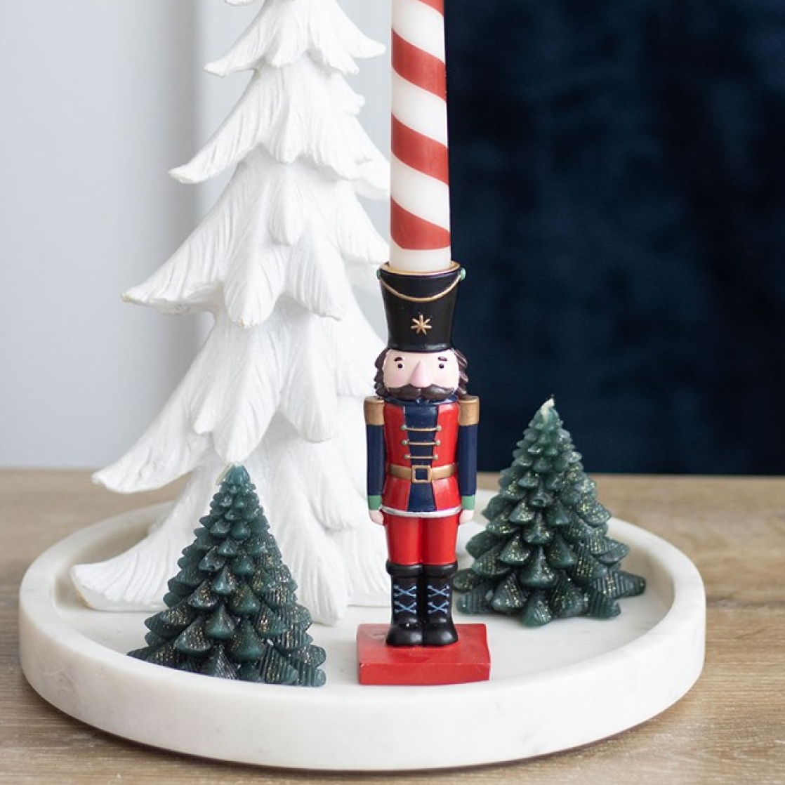 Traditional nutcracker shaped candle holder with complementing striped tapered candle. 
