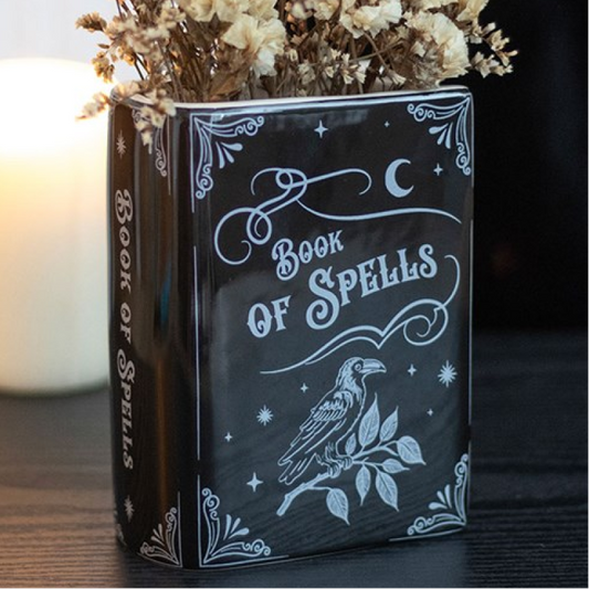 Book-shaped ceramic vase designed as an upright book of spells, complete with raven detailing. 